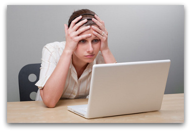 Young woman looking desperately at a laptop